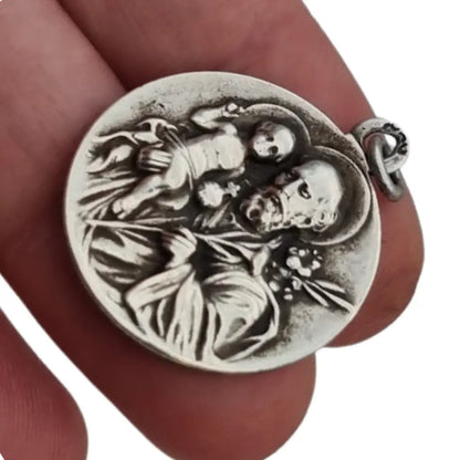 Medalla religiosa antigua en plata maciza de San José y el Niño fechada 1920.