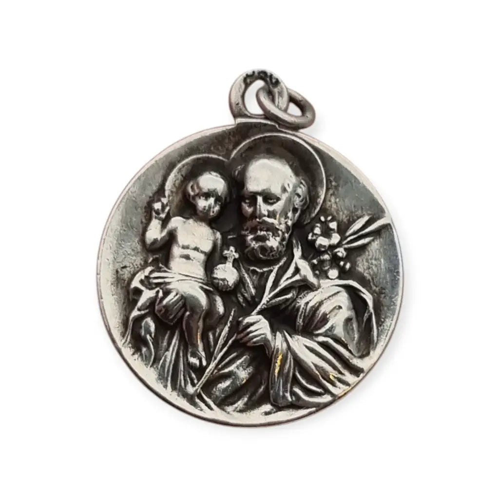 Medalla religiosa antigua en plata maciza de San José y el Niño fechada 1920.