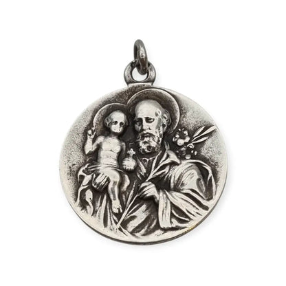 Medalla religiosa antigua en plata maciza de San José y el Niño fechada 1920.