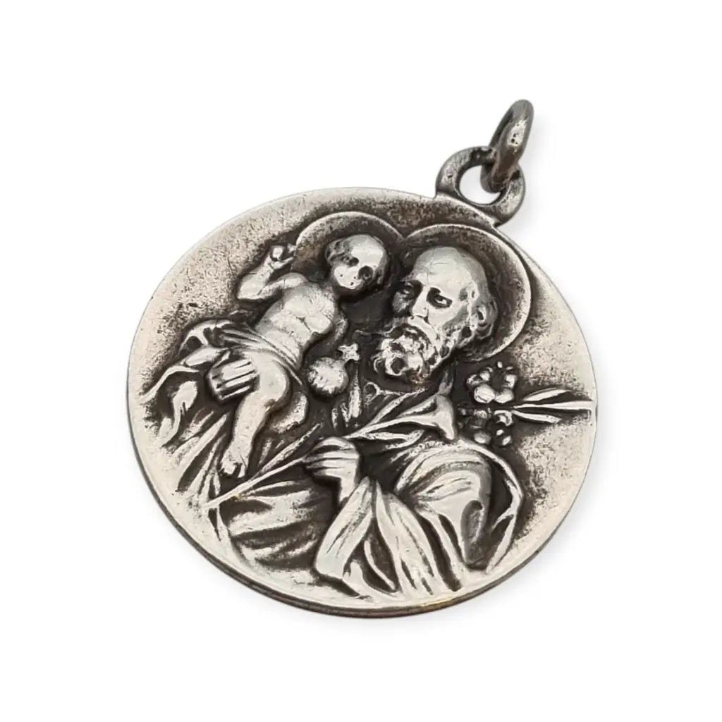 Medalla religiosa antigua en plata maciza de San José y el Niño fechada 1920.