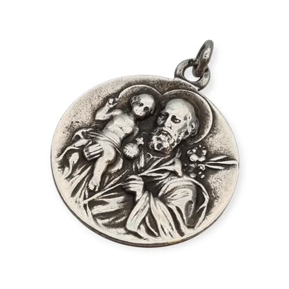 Medalla religiosa antigua en plata maciza de San José y el Niño fechada 1920.