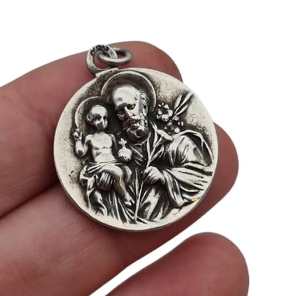 Medalla religiosa antigua en plata maciza de San José y el Niño fechada 1920.