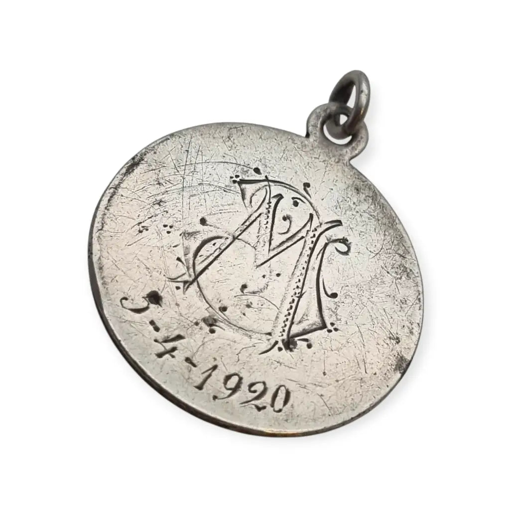 Medalla religiosa antigua en plata maciza de San José y el Niño fechada 1920.