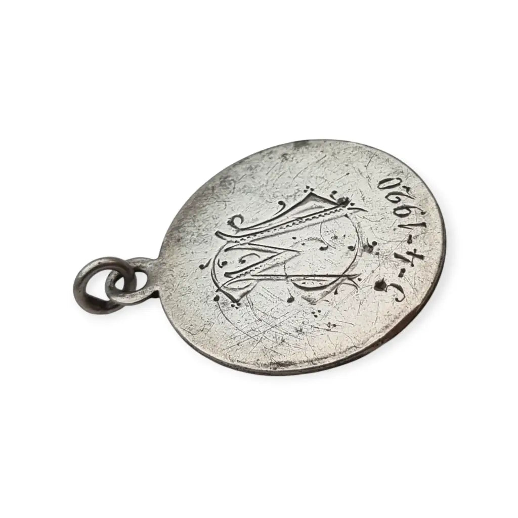 Medalla religiosa antigua en plata maciza de San José y el Niño fechada 1920.