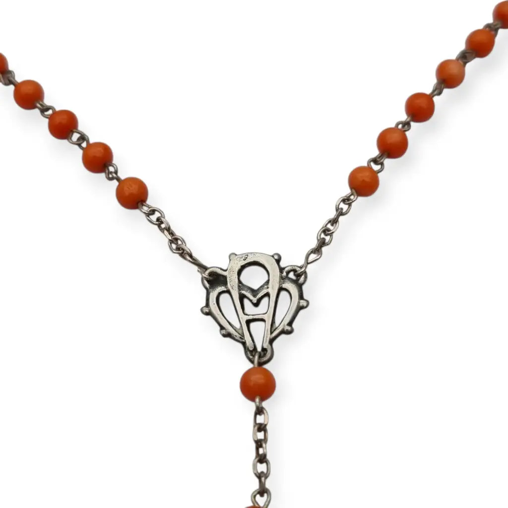Rosario en plata con cuentas de coral rojo cruz estilizada artesanal estilo