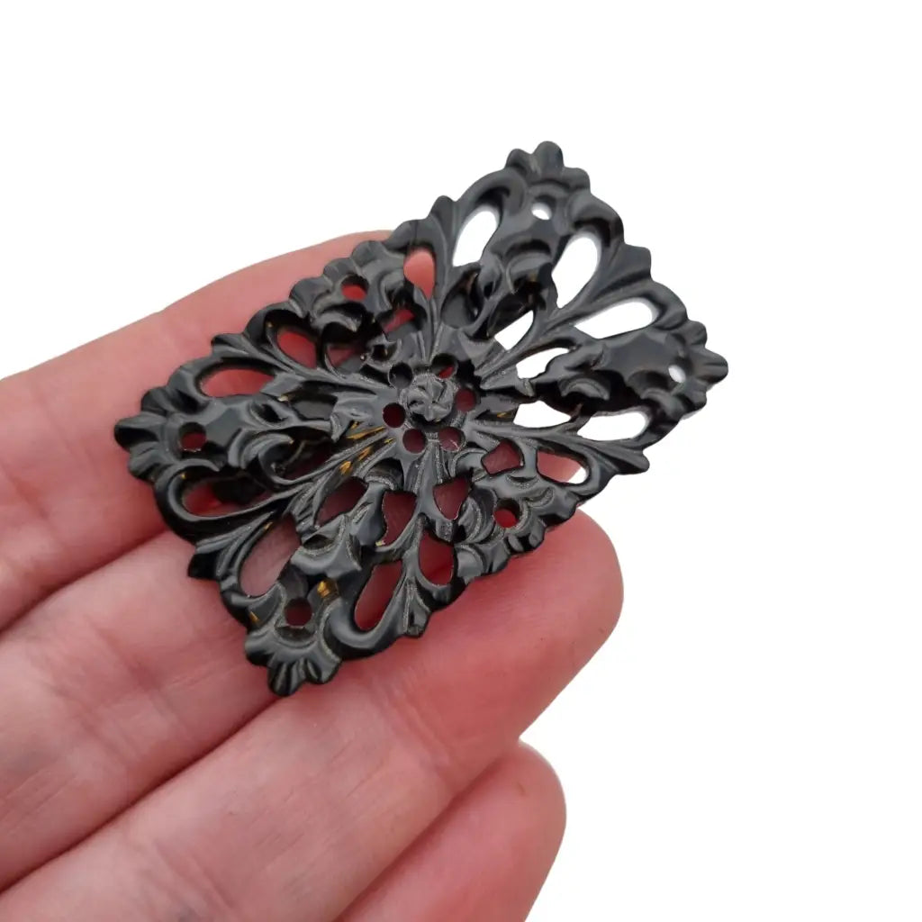 Broche vintage de baquelita tallada negra motivos florales para la solapa